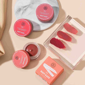 Beauty Glazed Velvet Super Matte Lip & Cheek Mud in pink, red, and brown shades with smudges on clear tray